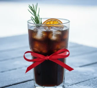 Ποτήρι Με Παγωμένο Χριστουγεννιάτικο Καφέ (Cold Brew), Αποξηραμένο Πορτοκάλι Και Χειμερινό Φόντο.